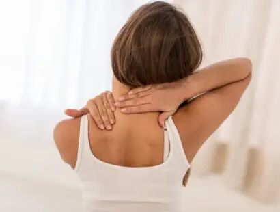 Woman holding her neck in pain, illustrating neck pain relief services at Messina Acupuncture in Setauket, NY